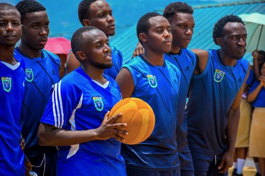 Basketball team in blue uniforms holding a ball, preparing for a game, showing team spirit.