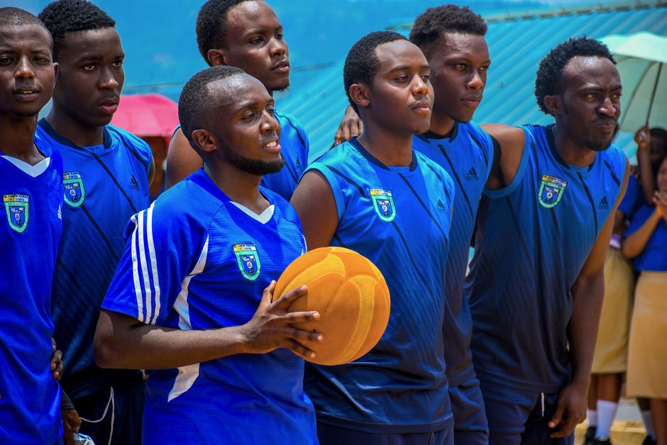 Basketball team in blue uniforms holding a ball, preparing for a game, showing team spirit.