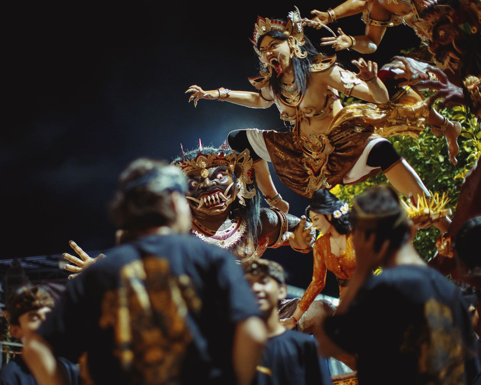 Nighttime Balinese celebration featuring traditional Ogoh-Ogoh puppets amidst vibrant cultural displays.