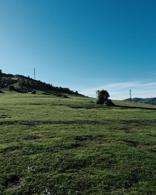 Free Vast landscape with green hills and clear blue sky, ideal for nature themes. Stock Photo