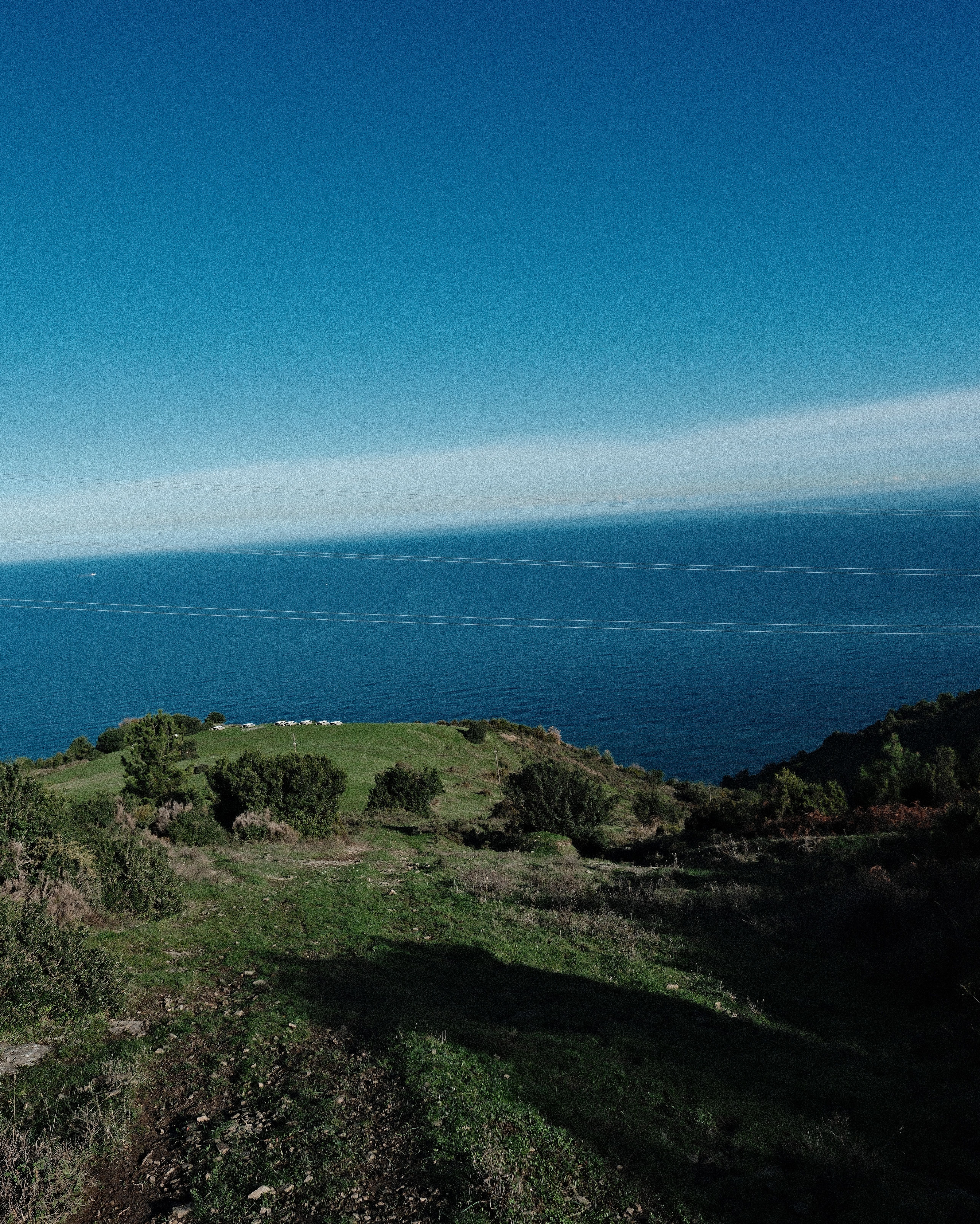 Scenic Coastal View with Green Hills and Ocean Horizon · Free Stock Photo