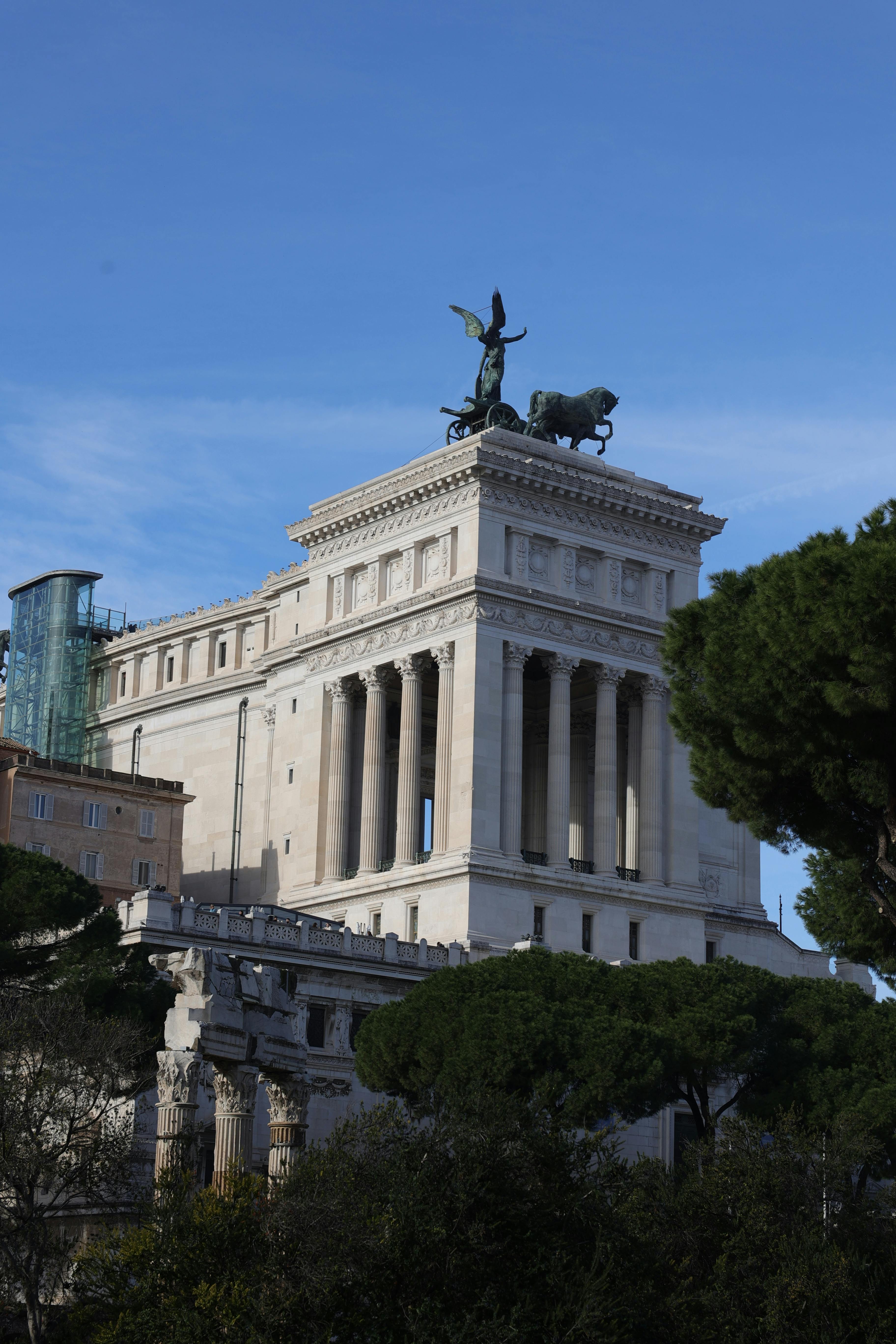 View of the Altare della Patria in Rome, Italy, with clear skies and surrounding greenery.