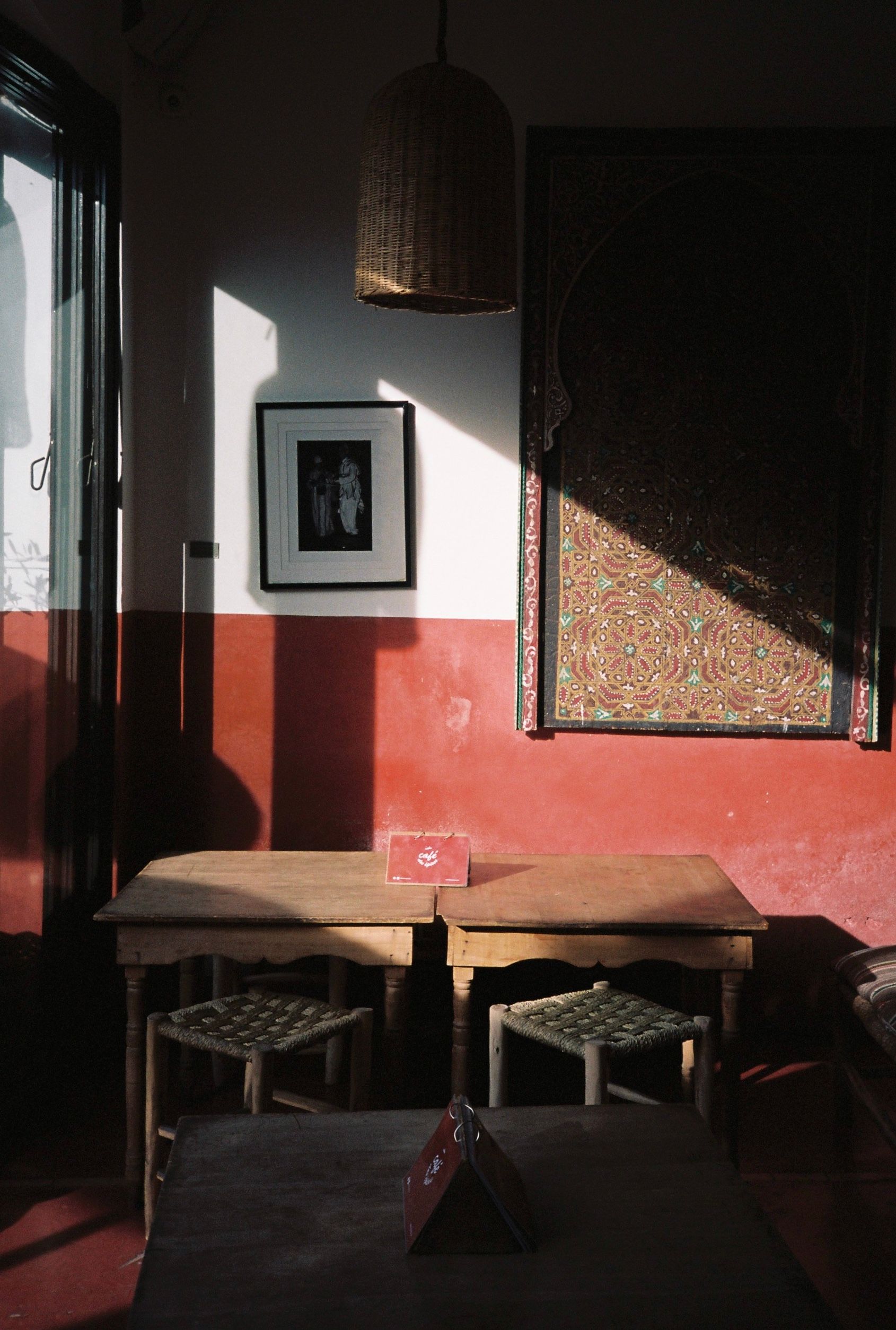 A cozy Moroccan room with traditional decor and warm sunlight casting shadows.