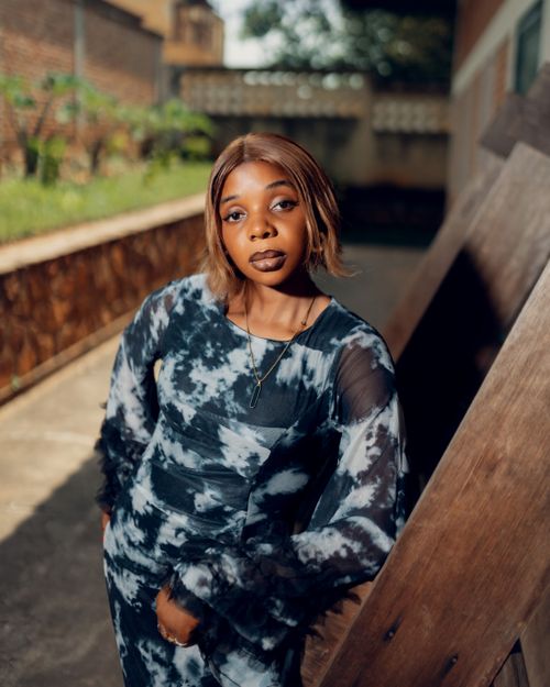 Free Confident young woman posing in a fashionable tie-dye dress in an urban outdoor setting. Stock Photo
