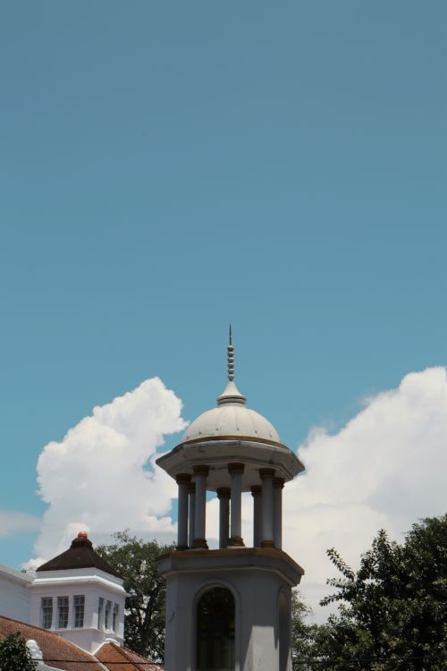 Free Elegant historic tower with a clear blue sky, showcasing classic architecture and natural beauty. Stock Photo