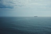 Cargo Ship on Calm Ocean under Cloudy Sky