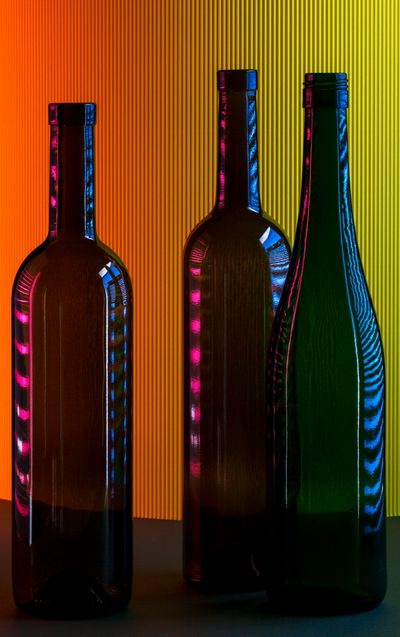 Three glass bottles catching coloured light — photo by Valentin Ivantsov on Pexels