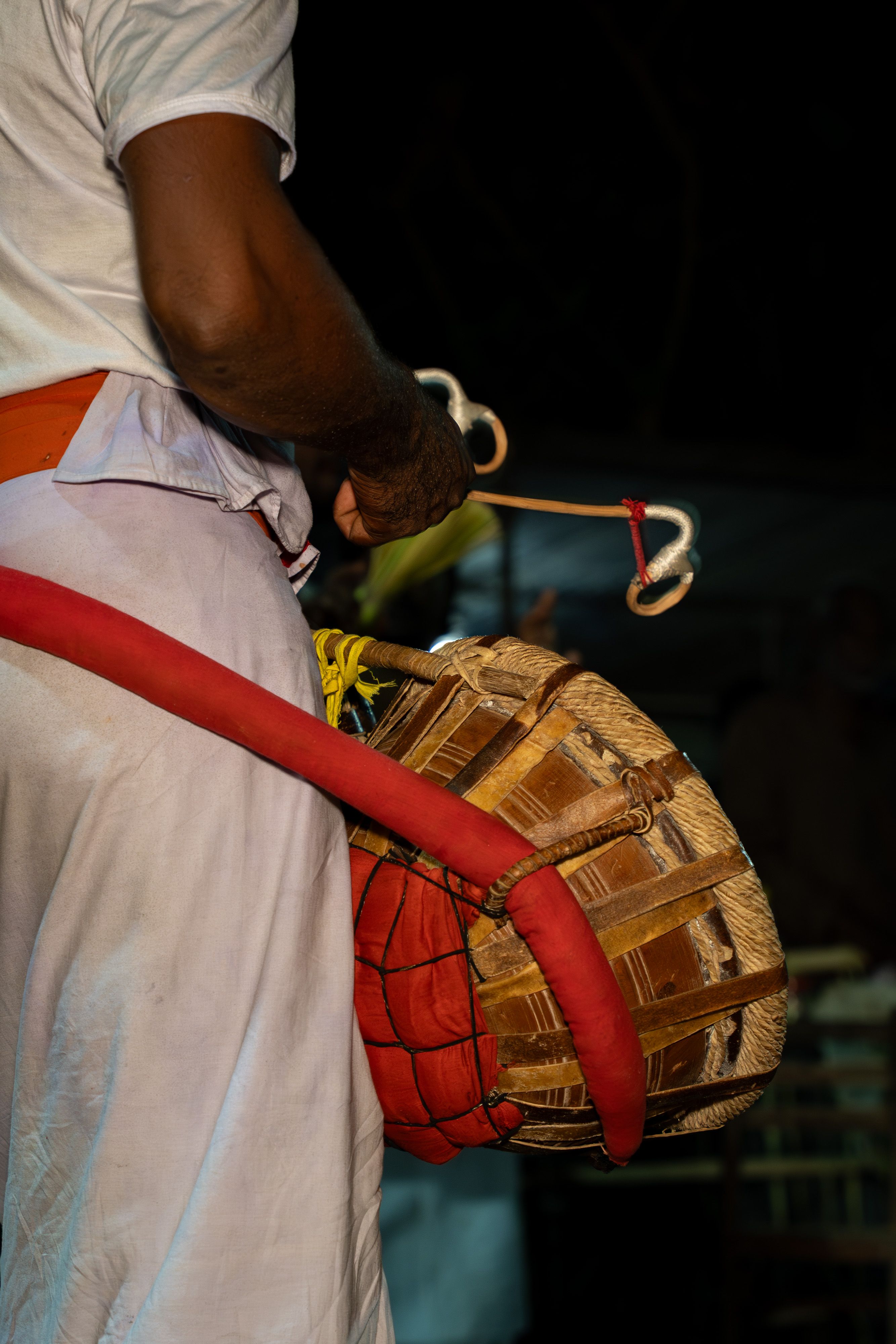 A vibrant depiction of a traditional Sri Lankan drummer performing with a drum at night.