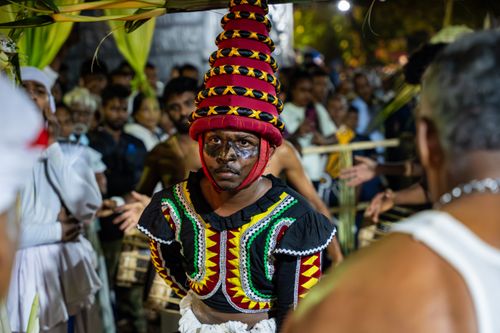 Free A traditional Sri Lankan performer in vibrant attire amidst a cultural festival crowd. Stock Photo
