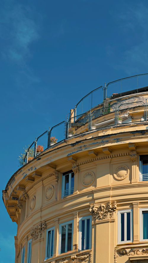 Free Detailed view of a classic building facade in Rome with clear blue skies. Stock Photo