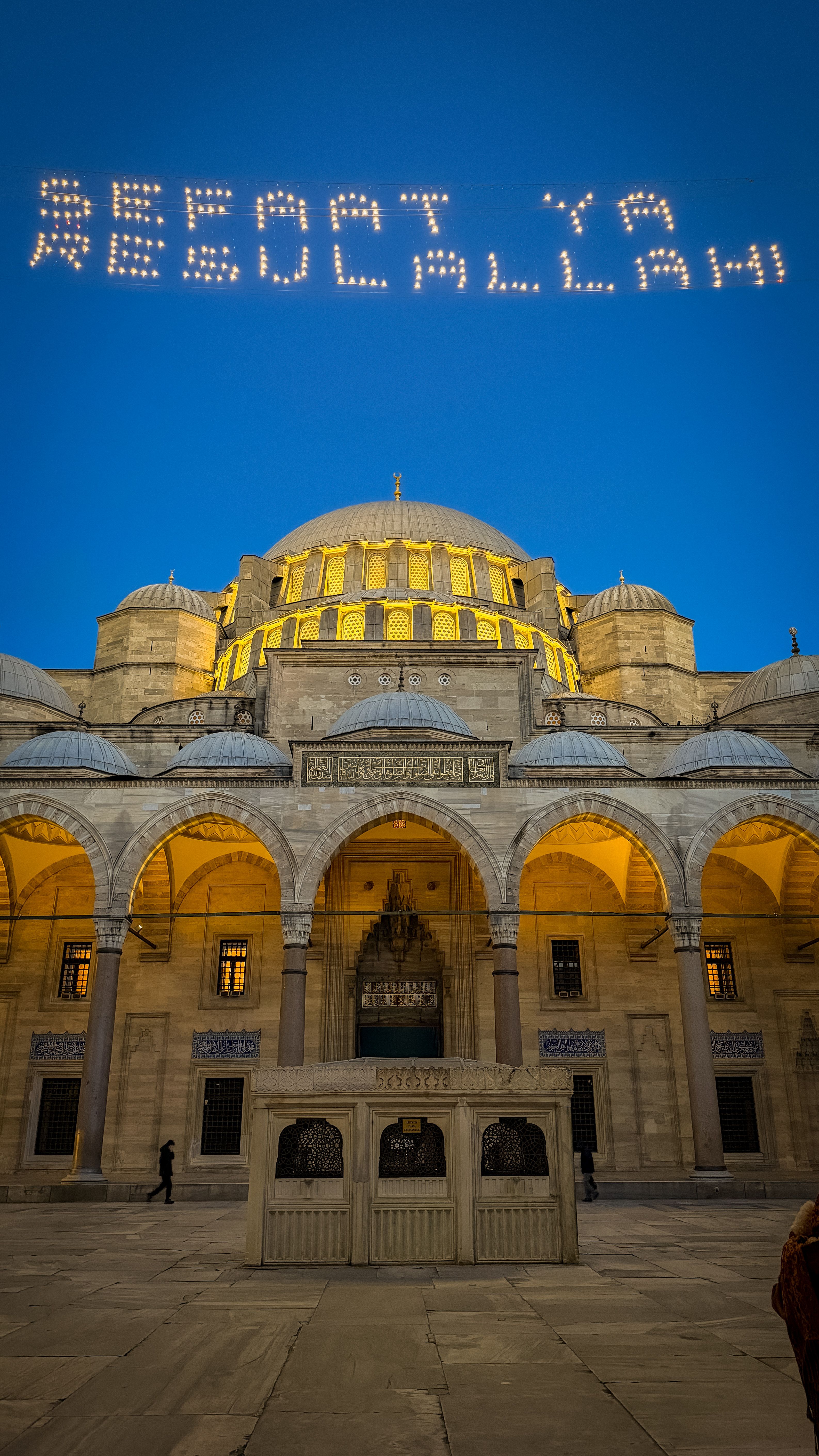Majestic view of Süleymaniye Mosque with night illumination and sky message, Istanbul.