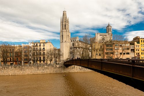 Free Beautiful view of Girona cityscape with the Onyar River and historic architecture under a blue sky. Stock Photo