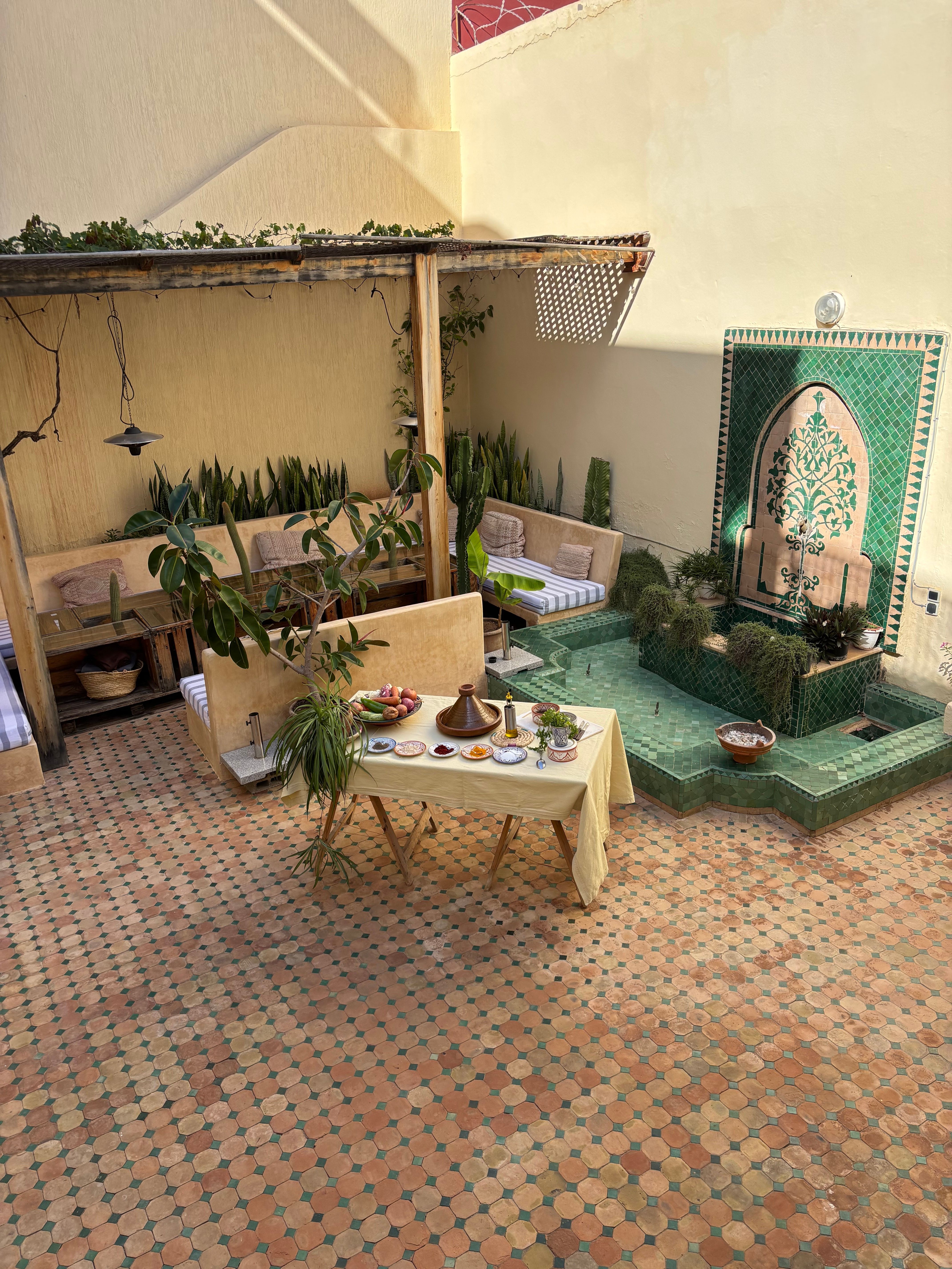Moroccan courtyard with fountain and family dining tables