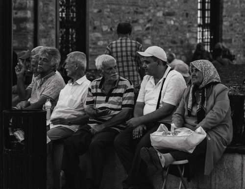 Free A group of senior adults socializing on a bench outdoors in black and white. Stock Photo