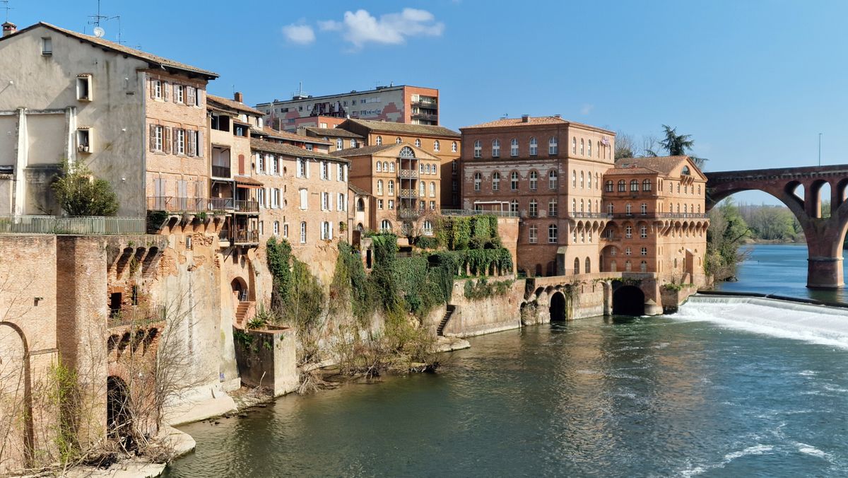 Façades anciennes en bord de rivière avec un pont en pierre