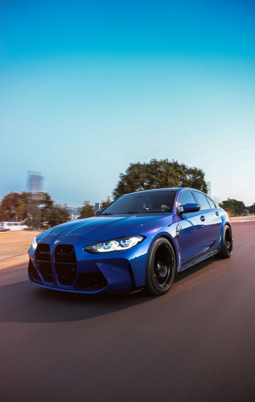 Free Blue sports car speeding on a road in Bursa, Türkiye, under a clear blue sky. Stock Photo