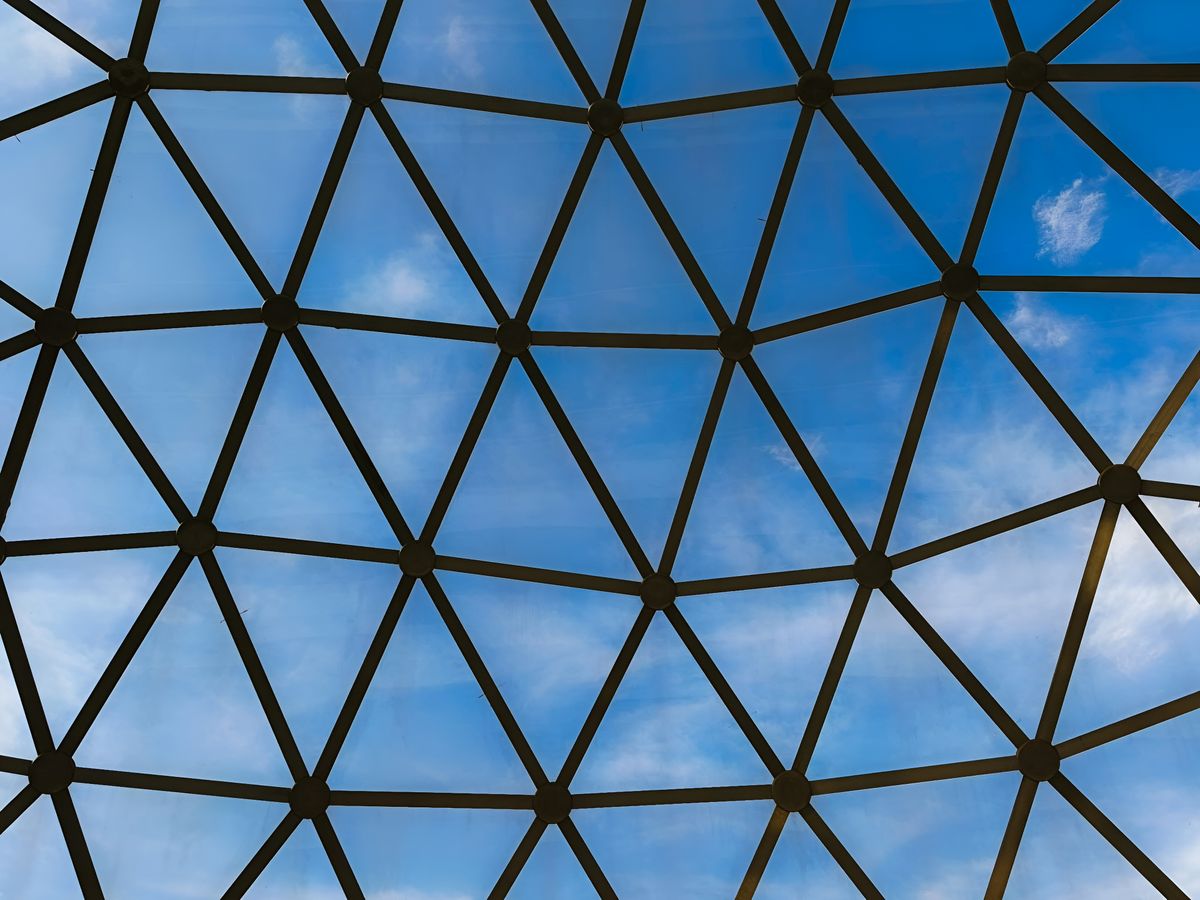 Cupola geodezica de sticla si otel pe cer albastru