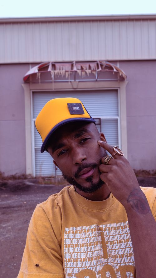 Free Fashionable young man with beard and cap posing in urban outdoor setting. Stock Photo