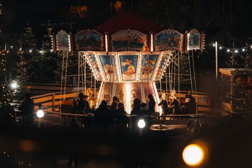 Free A charming nighttime scene of a carousel illuminated by festive lights at a Christmas fair in Rust, Germany. Stock Photo