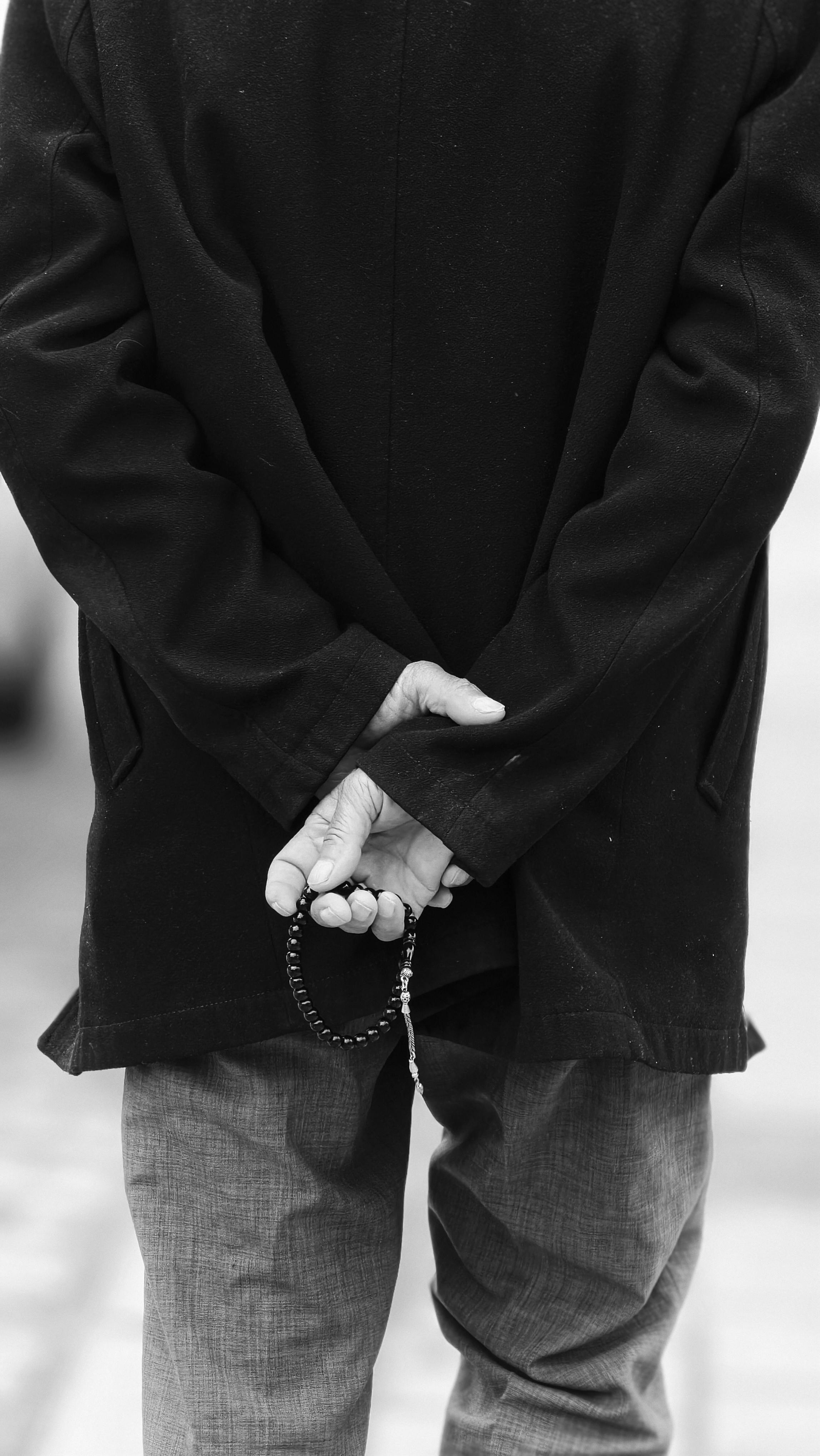Man Holding Prayer Beads in Thoughtful Pose