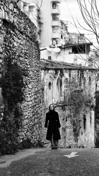 Woman walking on a historical street in Istanbul, showcasing old architecture.