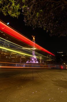 The iconic Angel of Independence monument in Mexico City captured at night with light trails from passing traffic.