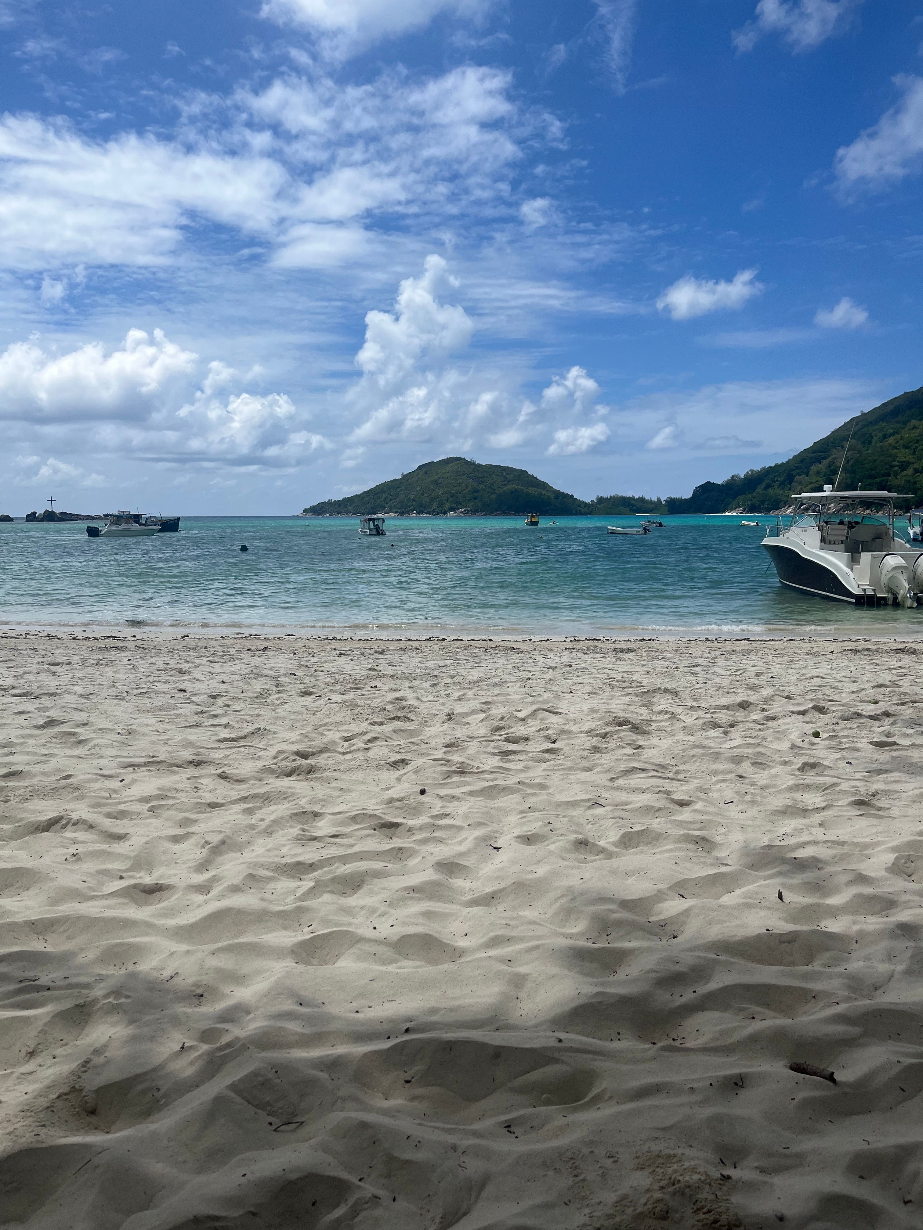 Idyllic sandy beach with boats in the turquoise waters of Seychelles.