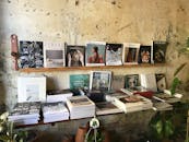 这家质朴的书店，木制书架上摆放着杂志、书籍和室内植物，它们靠在纹理墙壁上