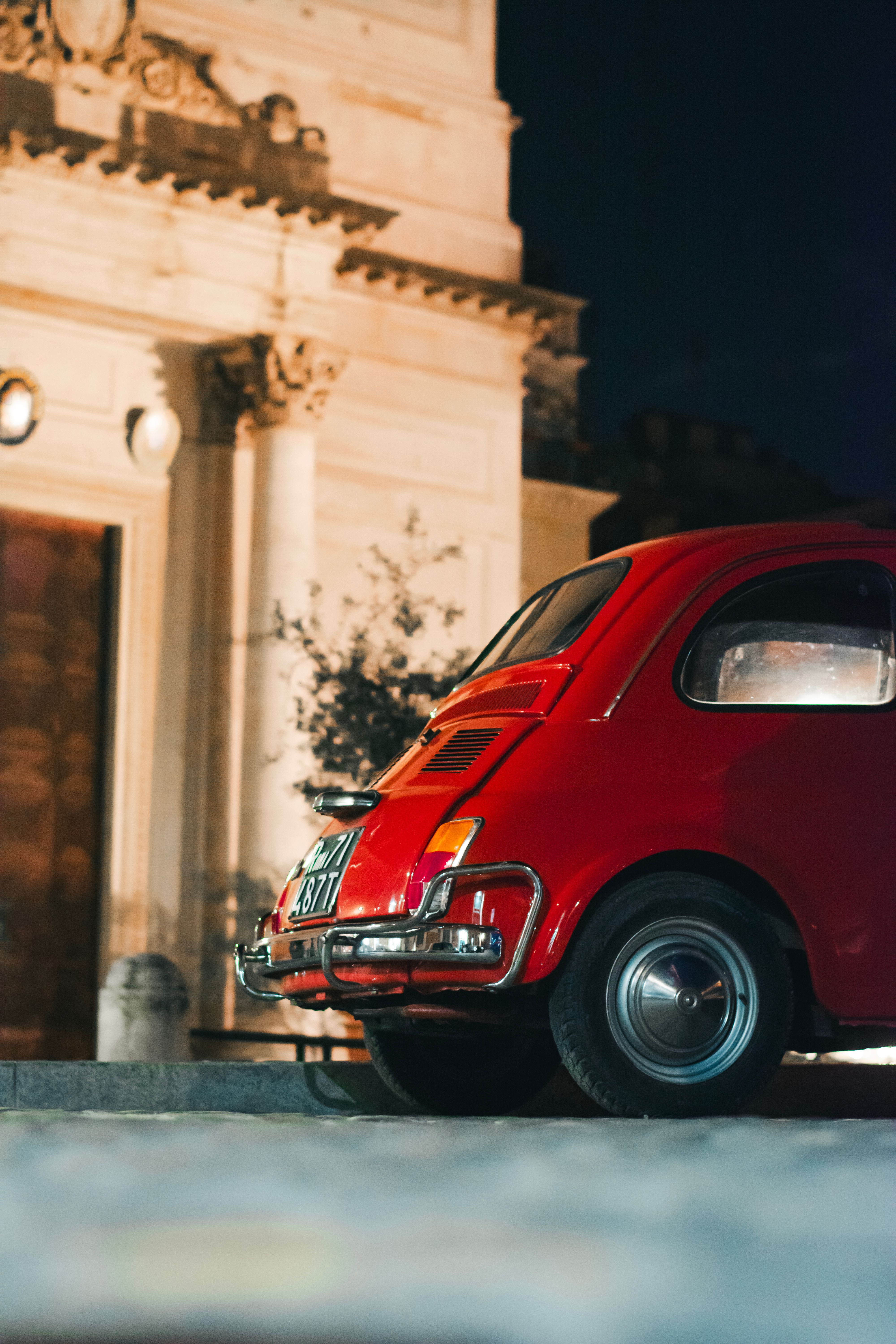 Vintage Red Car Parked by Historic European Building · Free Stock Photo