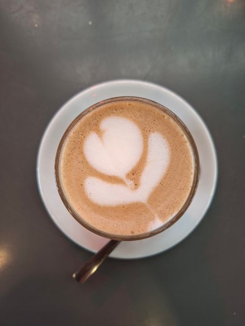 Free Aerial view of a latte with beautiful heart-shaped foam art on a table Stock Photo