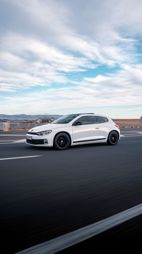 Free A sleek white sports car speeds along a highway in Ankara, Türkiye, under a vibrant sky. Stock Photo