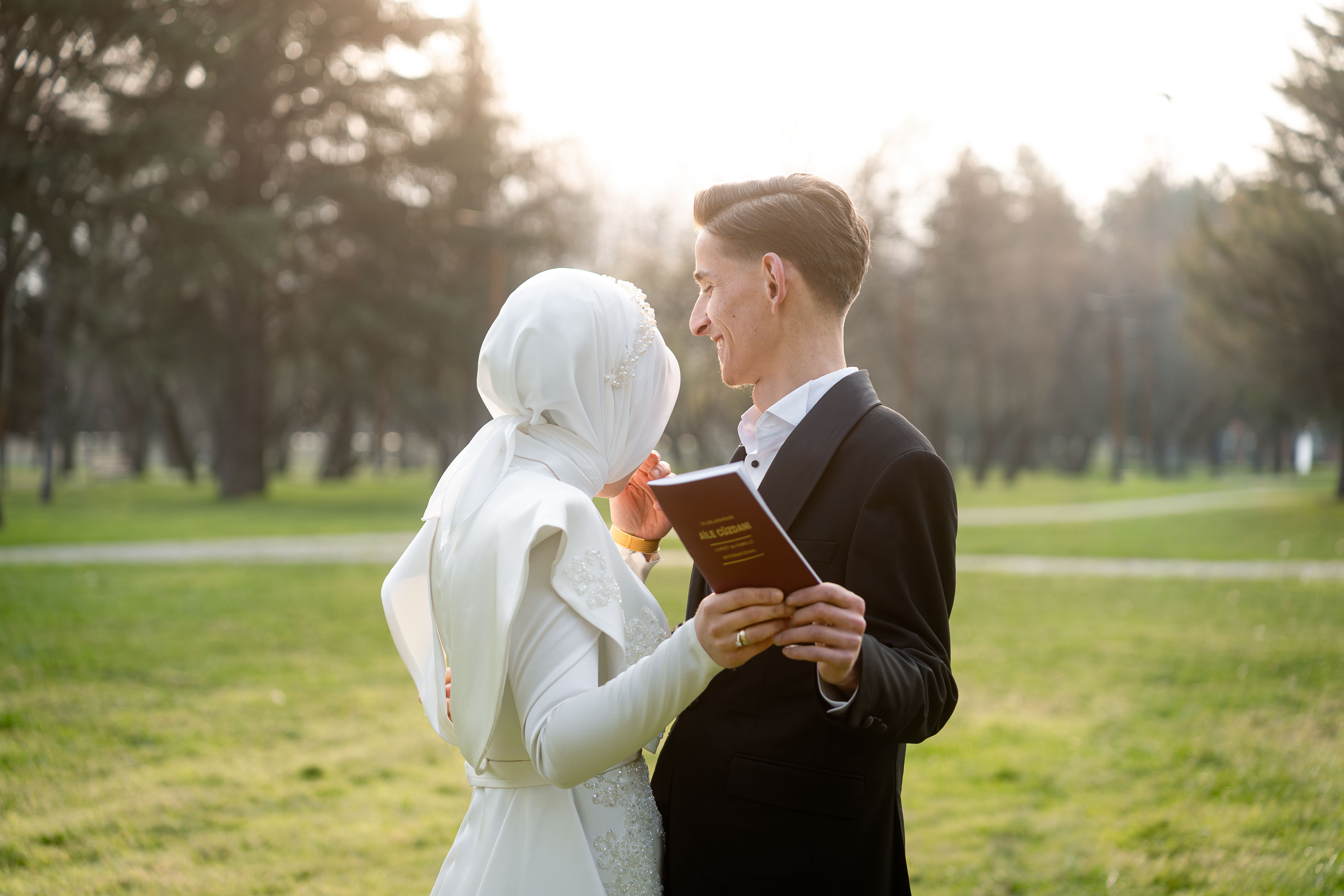 A couple celebrates their wedding in an outdoor setting during a beautiful sunset, capturing a romantic and joyful moment.