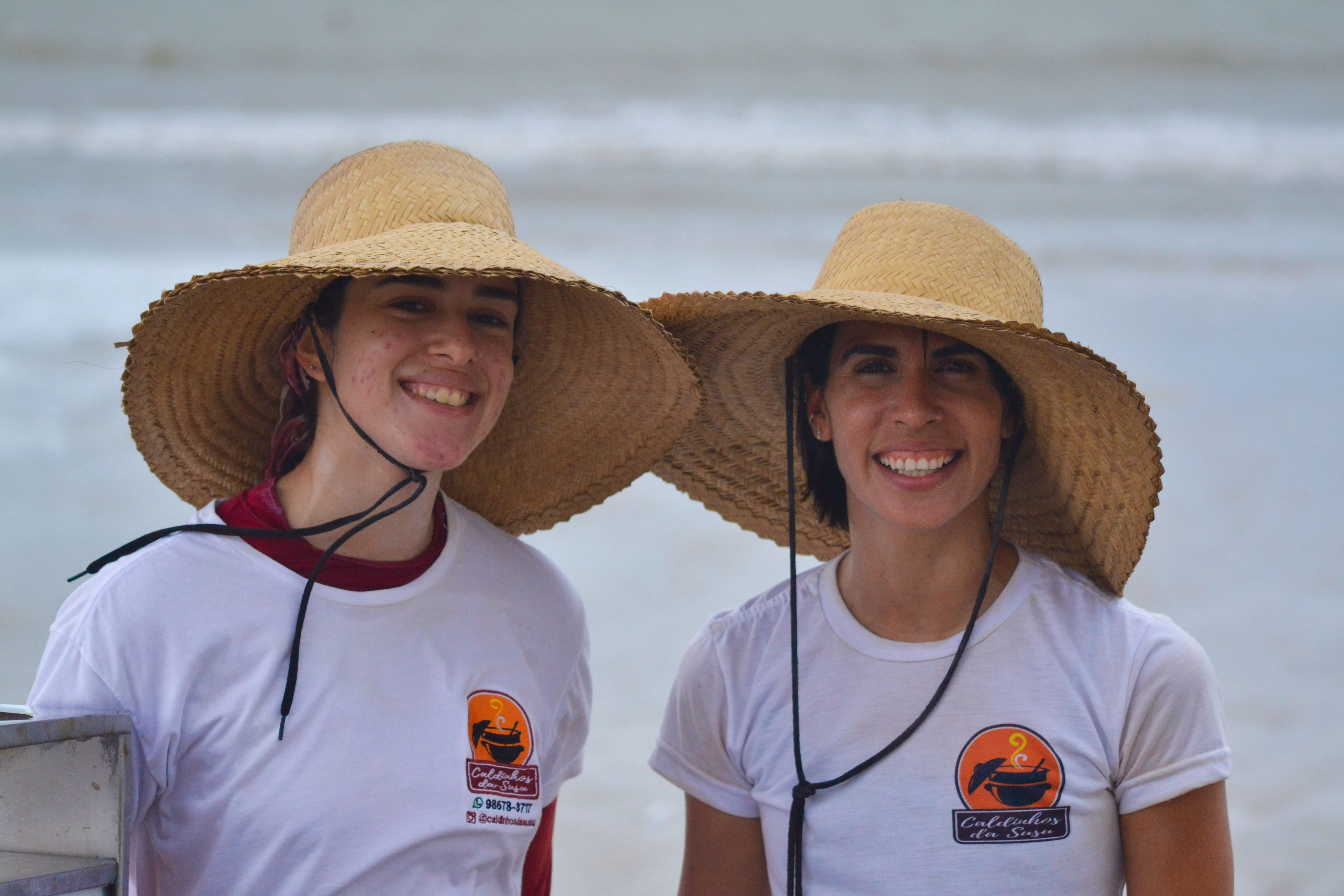 Smiling Women in Straw Hats on Beach · Free Stock Photo