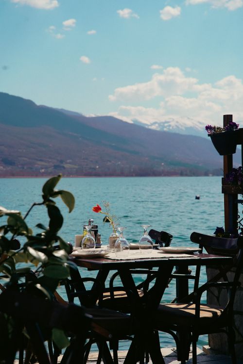 Free Picturesque lakeside dining experience in Ohrid, North Macedonia with stunning mountain views. Stock Photo
