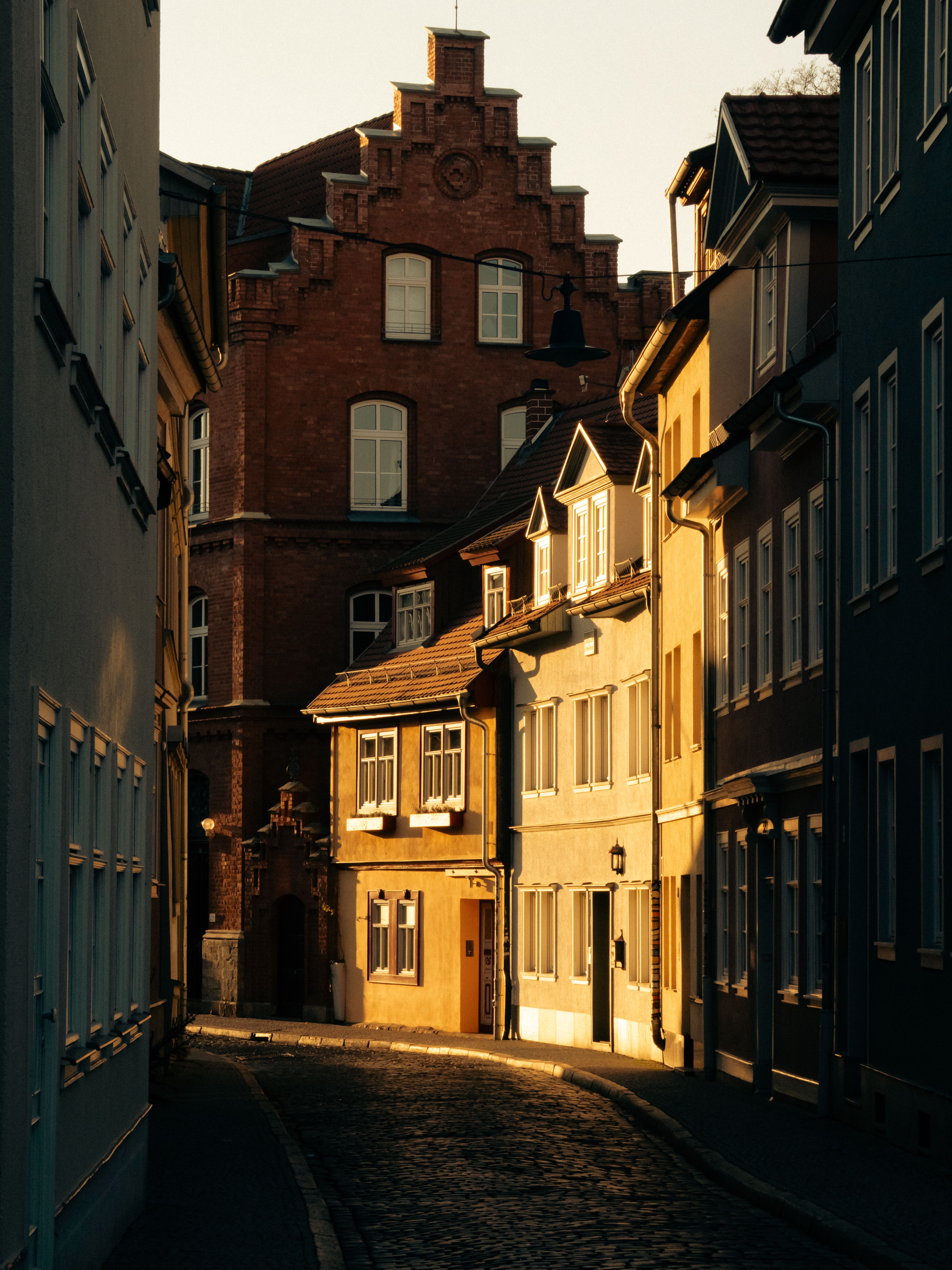 Historic European street with sunlight illuminating classic architecture.