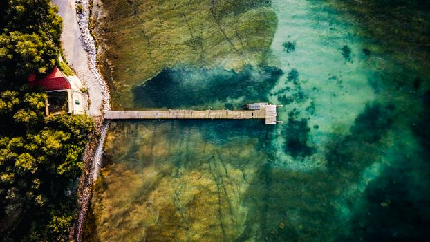 A serene aerial view of a pier extending into Lake Garda, Sirmione, Italy.