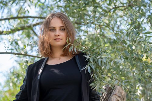 Free A young woman enjoys a sunny day in a Finnish park with lush greenery. Stock Photo