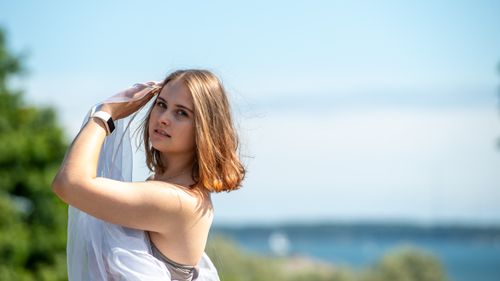 Free A young woman enjoys a sunny summer day in Helsinki's Kaivopuisto Park, surrounded by nature. Stock Photo