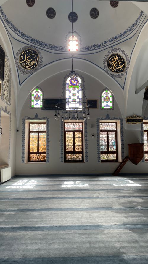 Free Interior view of a historic mosque in Kastamonu, Türkiye, featuring stained glass windows and Islamic calligraphy. Stock Photo