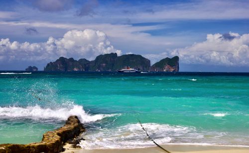 Free Stunning beach scene with turquoise waters, distant island, and clear skies. Perfect for tropical getaways. Stock Photo