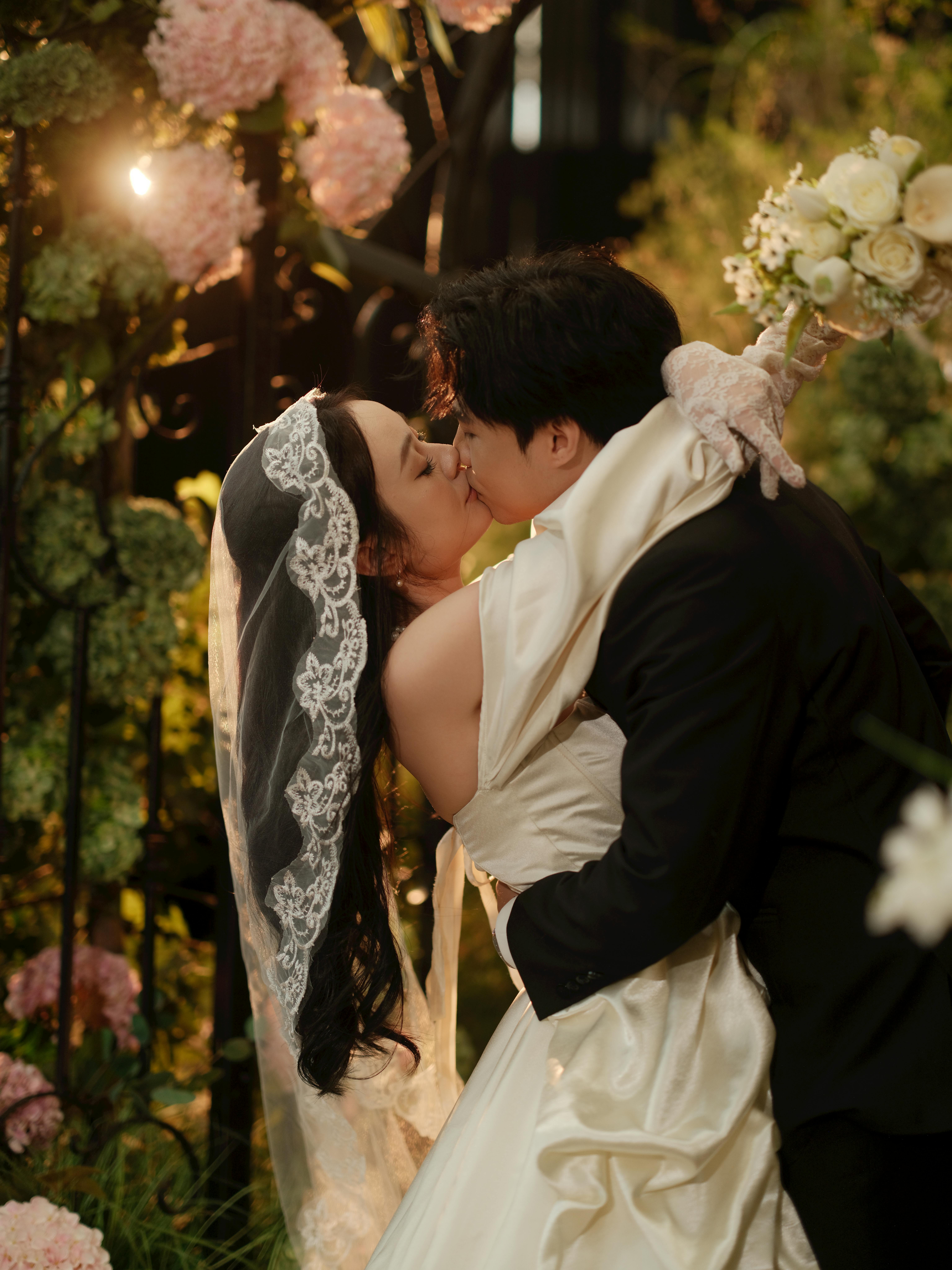 Romantic Wedding Kiss in Lush Garden Setting