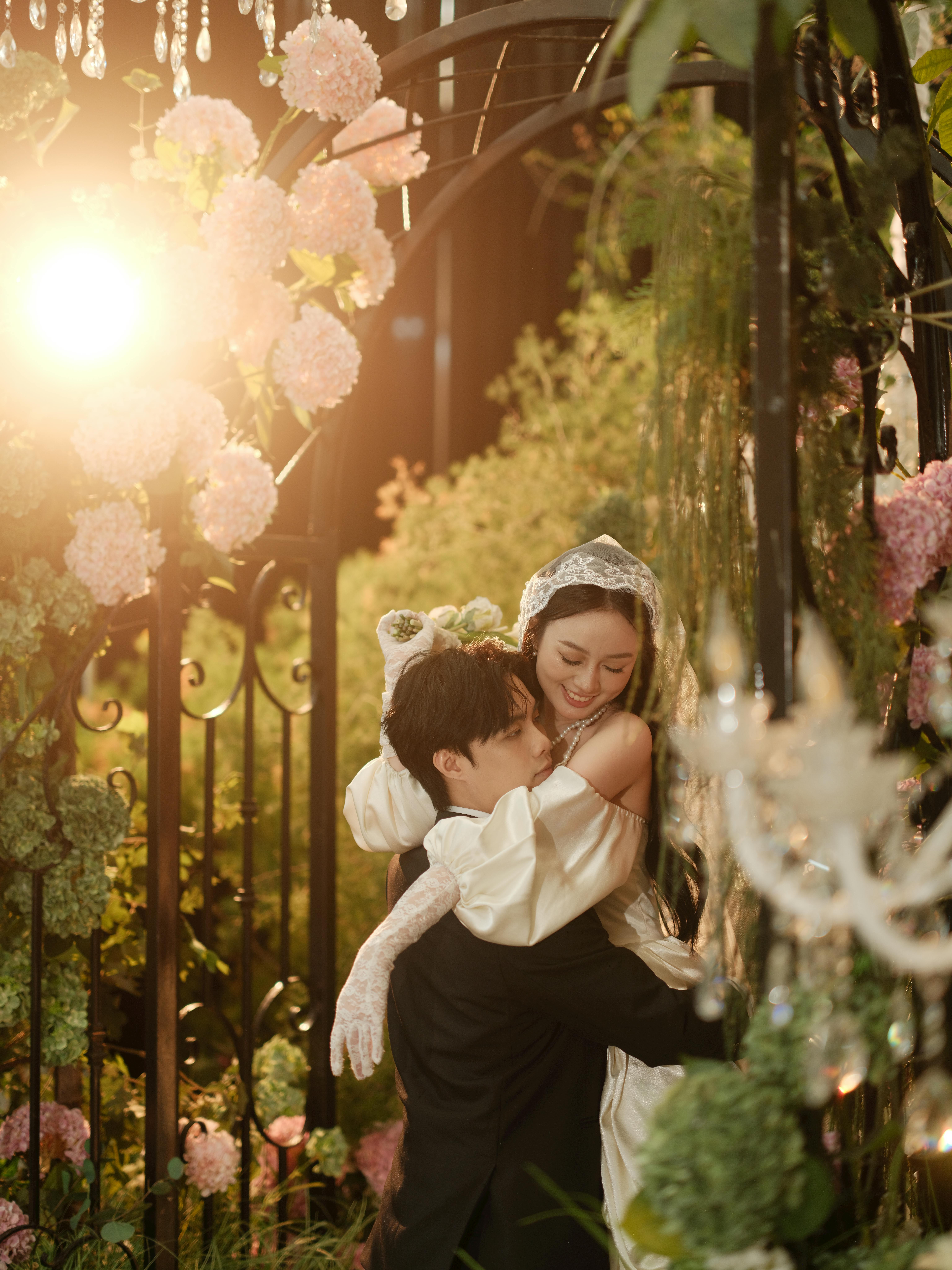 Romantic Couple Embracing in Sunlit Floral Garden