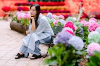 Woman relaxing among vibrant hydrangeas in garden