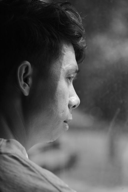 Free Black and white side profile of a man gazing out a window, introspective mood. Stock Photo