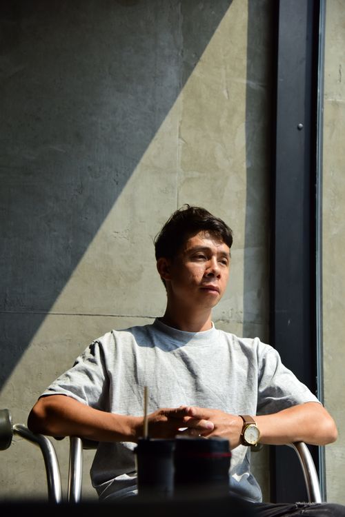Free Casual mid-adult man sitting by window in soft sunlight indoors, expressing deep thought. Stock Photo