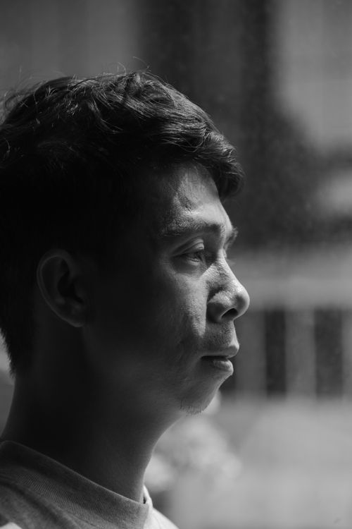 Free Close-up black and white profile portrait of a person indoors with thoughtful expression. Stock Photo