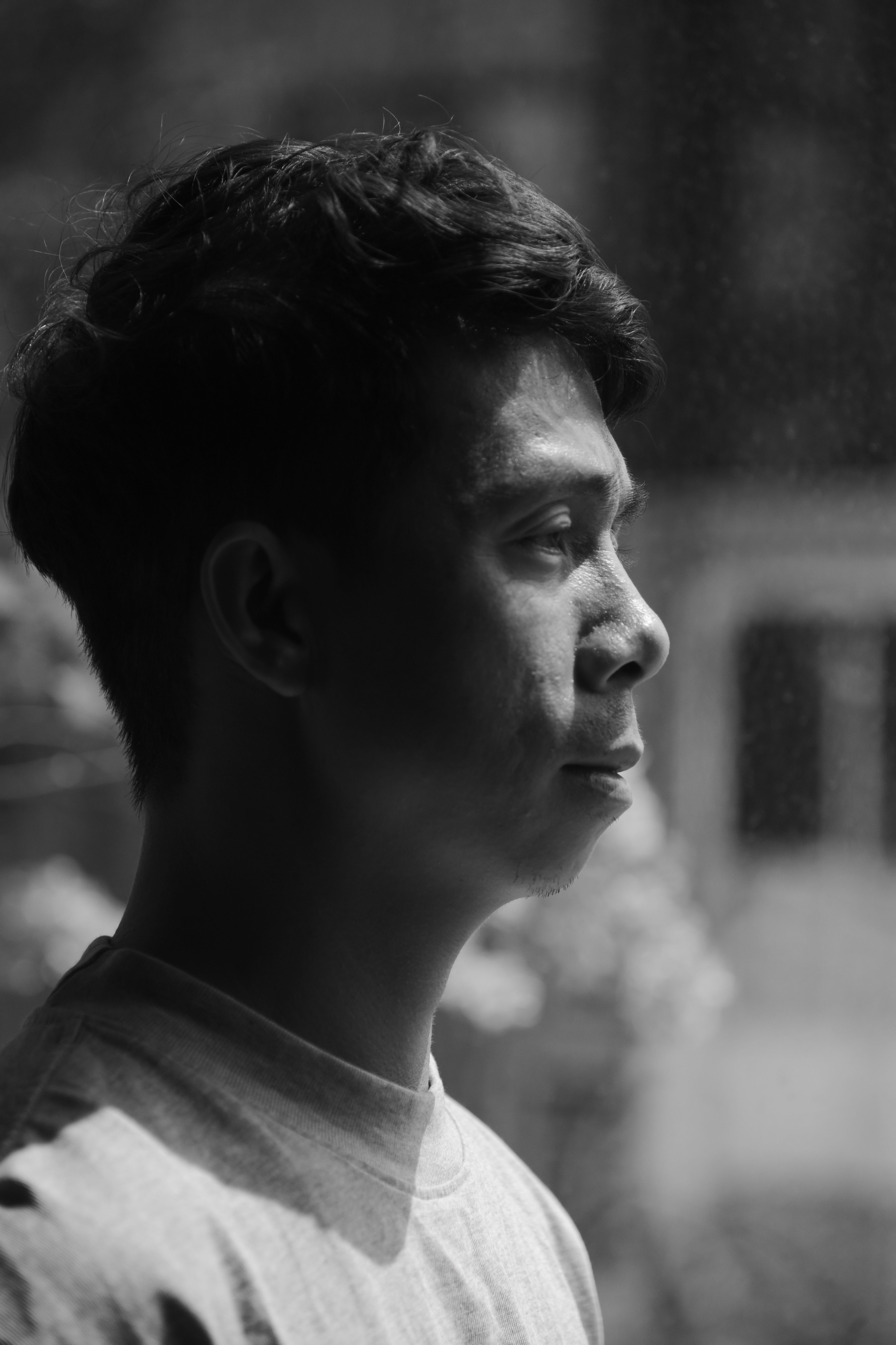 Black and white side profile portrait of a young man in thoughtful contemplation.