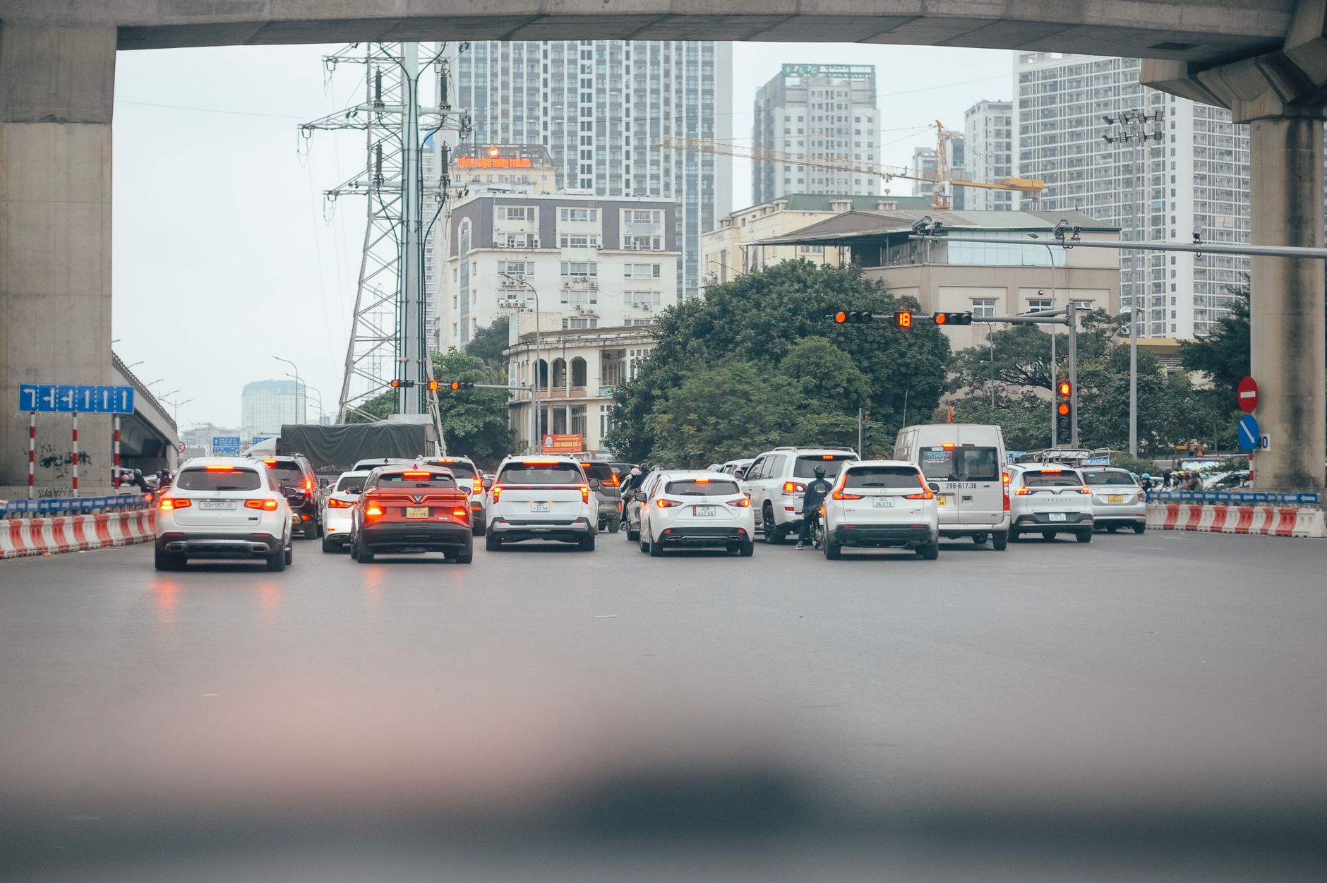City traffic on a busy urban street with high-rise buildings and a traffic light signal.