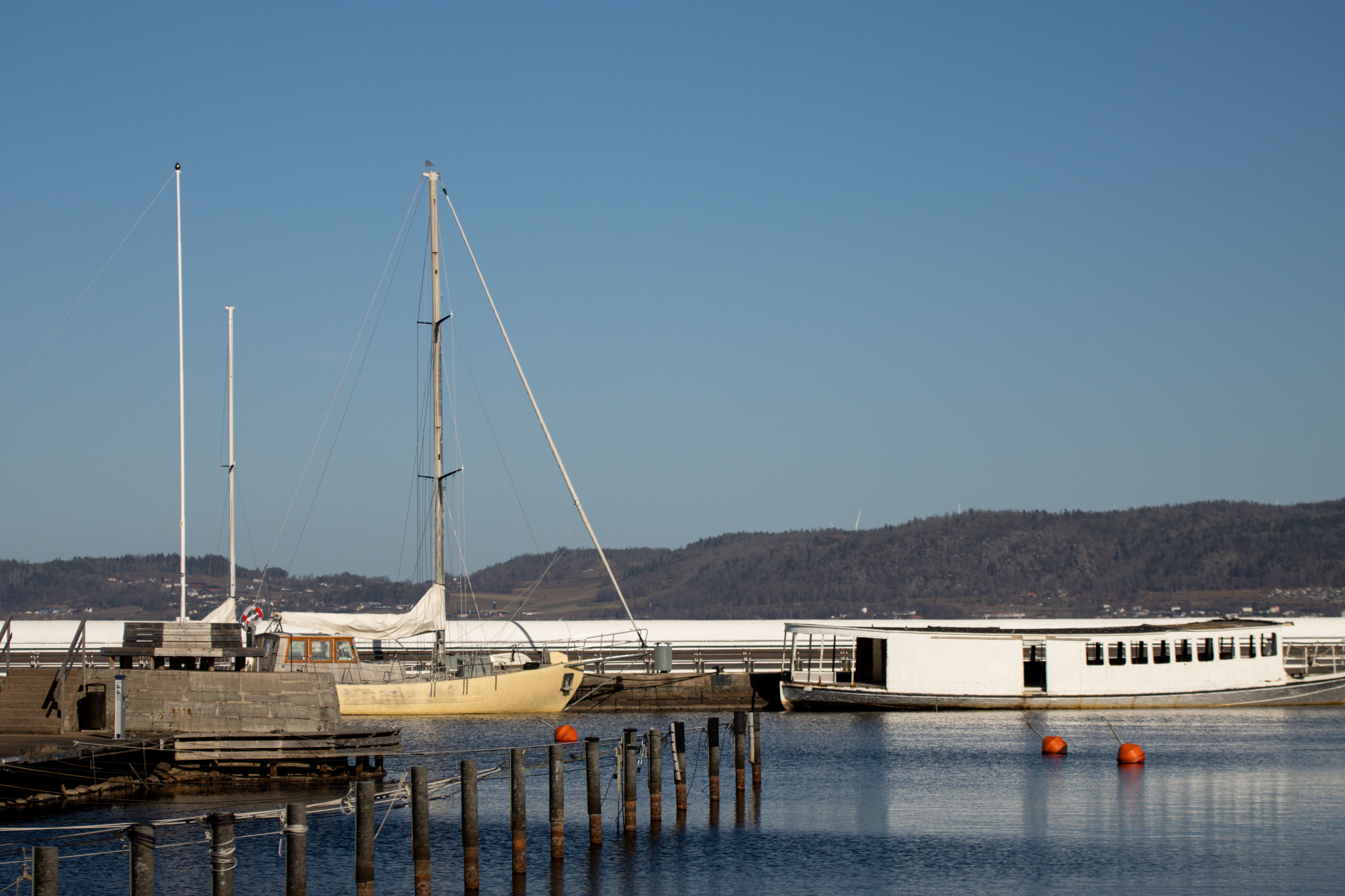 Peaceful lakeside scene at Jönköping harbor with boats and a clear sky.