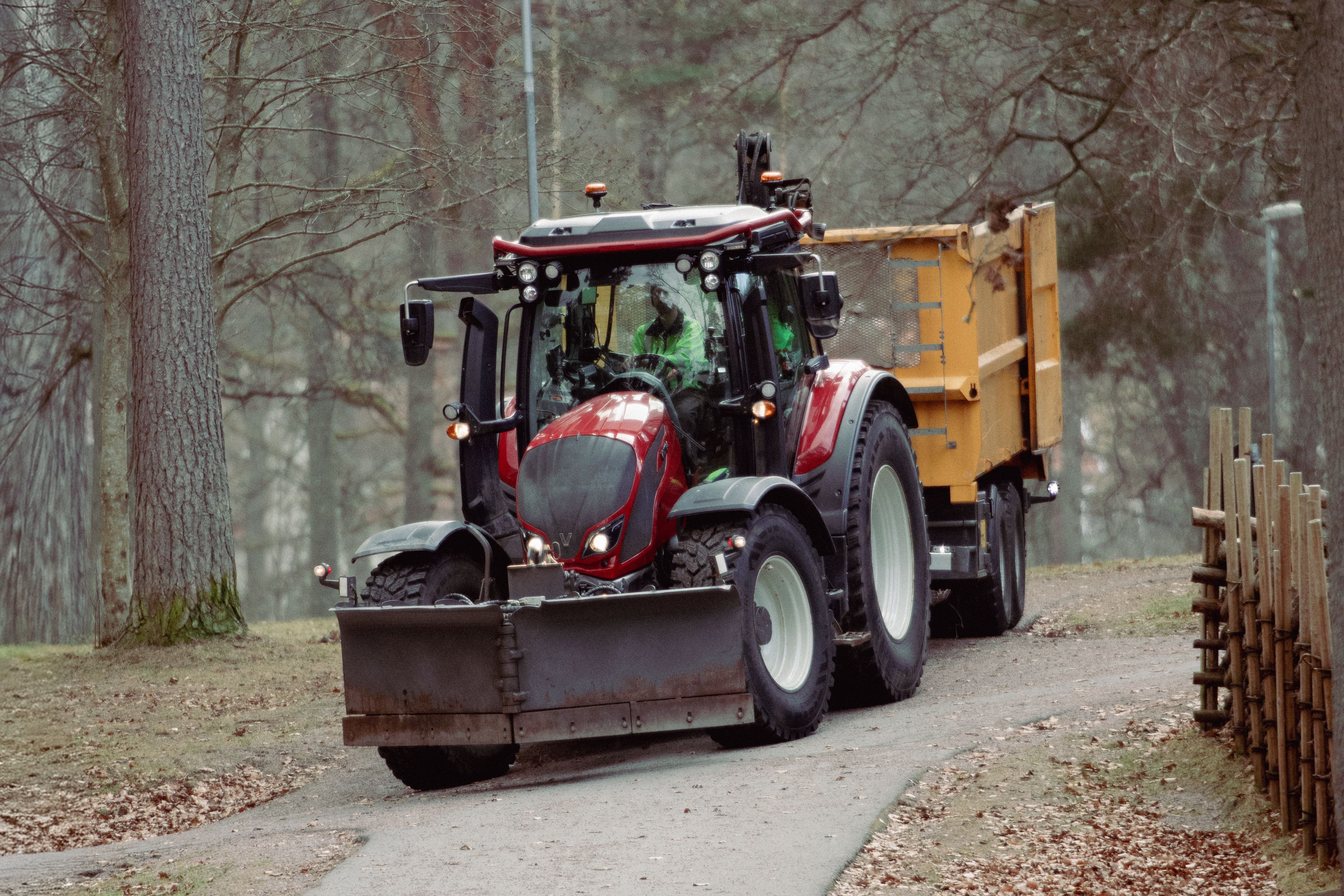A red tractor drives through a forest in Jonkoping, Sweden, on an autumn day.